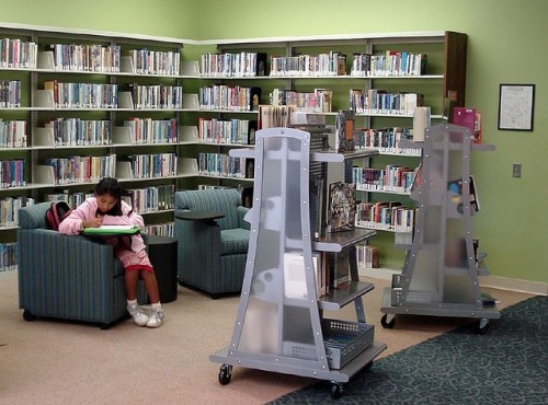 teen girl working at a chair in a public library