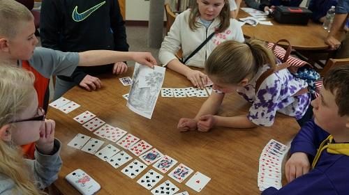 Children playing with cards to illustrate one of the puzzles in the lockdown room.